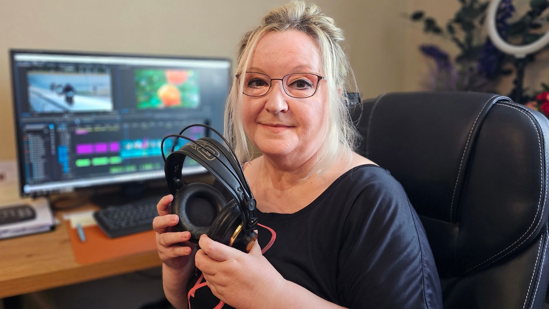 Ina Siptitz sitzt vor einem Rechner mit Premiere Pro und Kopfhörern in der Hand Forst TV
